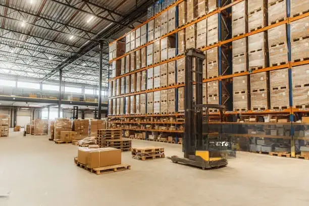 Warehouse with stacked boxes and forklift showcasing large-scale custom packaging solutions in the US